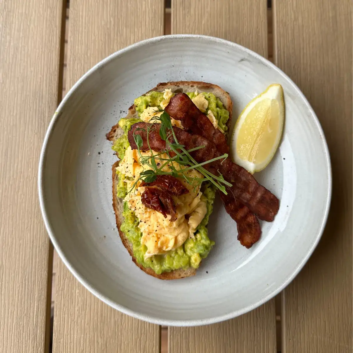 Soft-scrambled eggs and bacon piled on a thick slice of naturally leavened sourdough