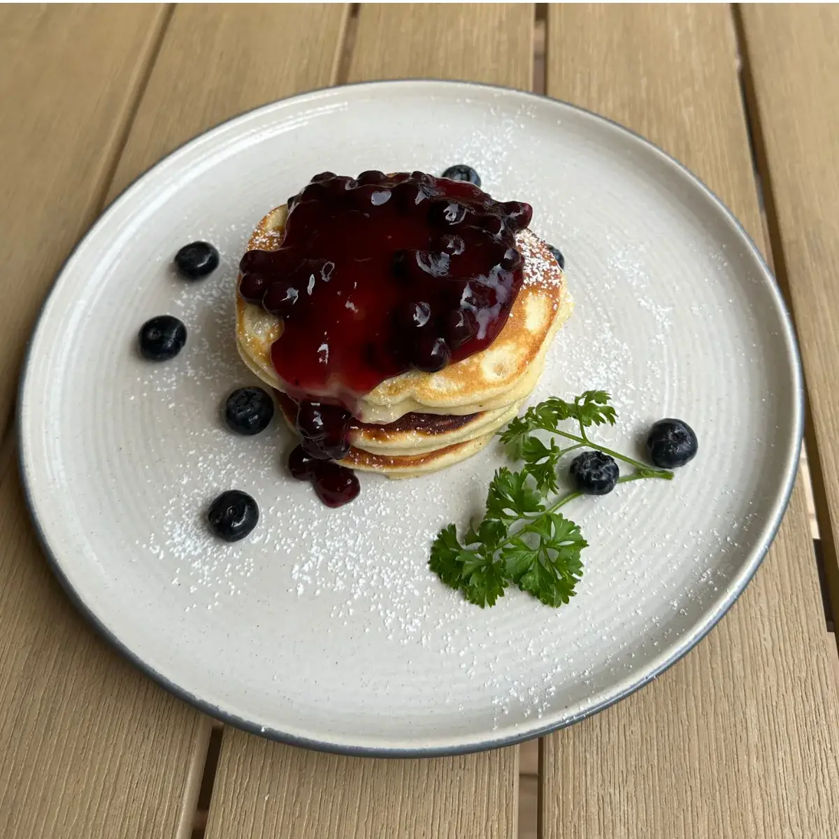 A stack of blueberry pancakes griddled to order and dusted with sugar