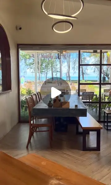 The long table by the window with the sea and casuarina trees of Nopparat Thara in view
