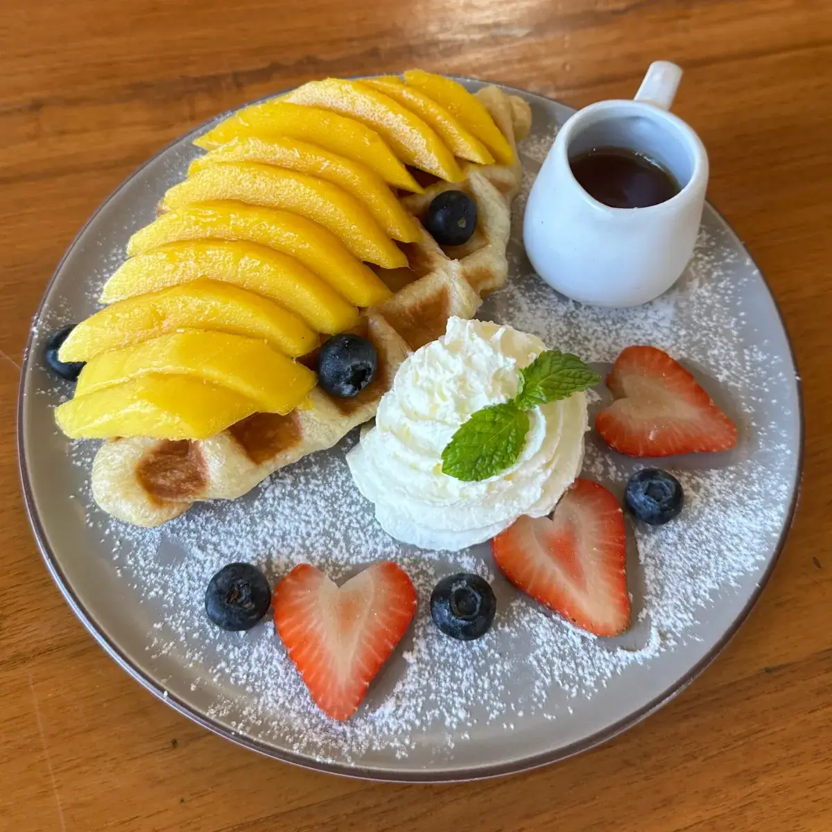 A warm mango croffle topped with a scoop of ice cream — the house afternoon order