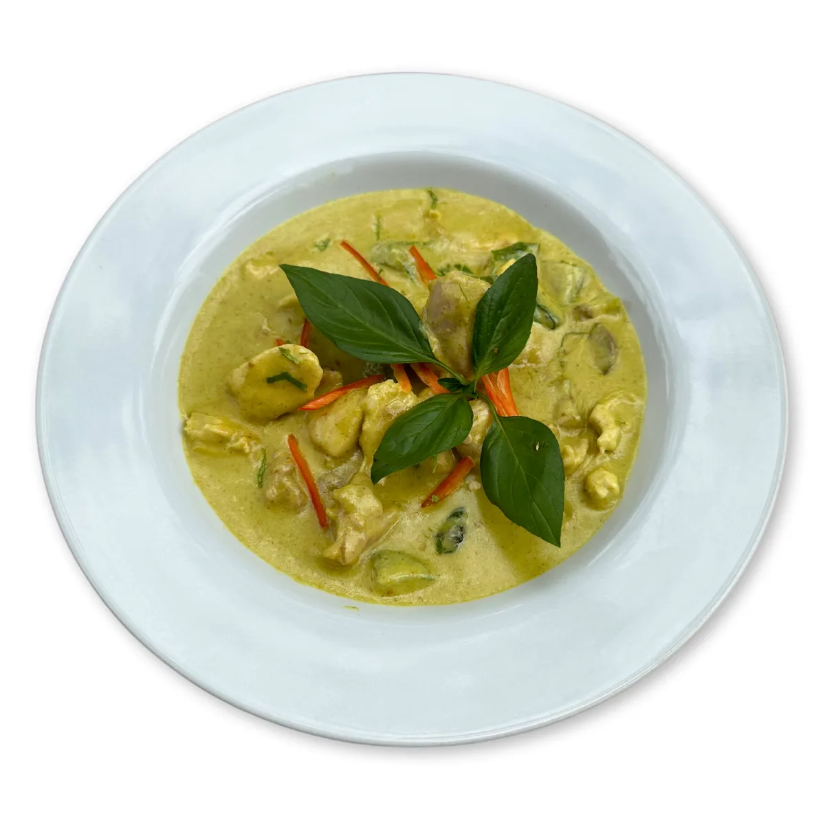 A bowl of Thai chicken green curry with sweet basil, sliced chilli and coconut milk